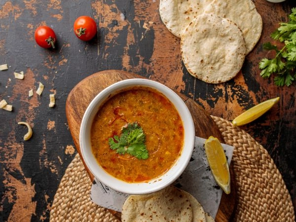Gustare la zuppa Madrooba, specialità emiratina dalla consistenza cremosa e ricca di sapore