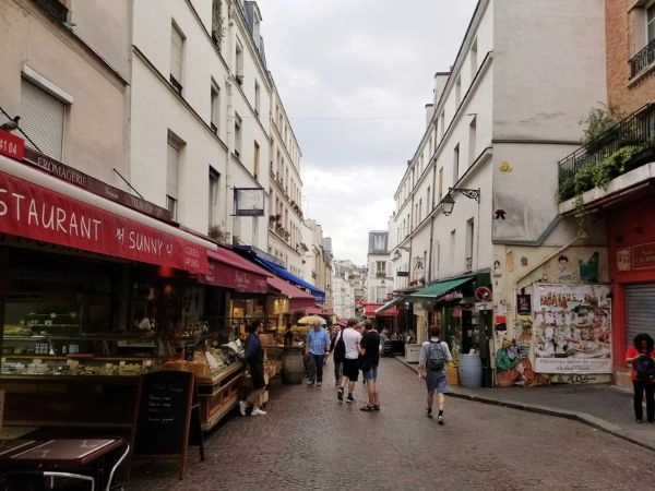 Passeggiare lungo Rue Mouffetard tra bancarelle gastronomiche, negozi storici e caffè parigini