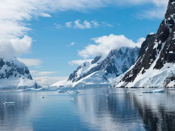 Navigare nel Canale Lemaire, stretto passaggio antartico circondato da montagne innevate e ghiacciai imponenti