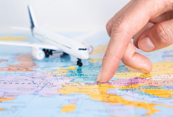 dito-puntato-su-mappa-geografica-viaggio-aereo