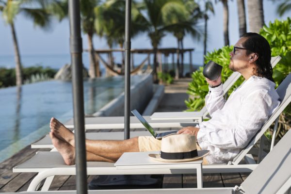 work-ation-lavorare-in-vacanza-uomo-in-piscina-lavora-mentre-si-rilassa