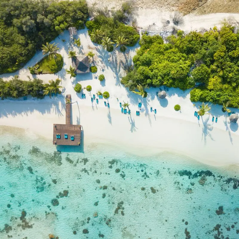 Panorama di un atollo delle Maldive con mare turchese e bungalow di lusso Panorama di un atollo delle Maldive con mare turchese e bungalow di lusso