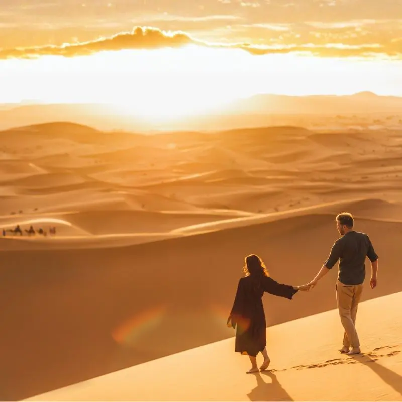 Coppia in viaggio di nozze tra le dune rosse del deserto di Wahiba Sands in Oman.