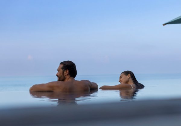 coppia-di-sposi-in-viaggio-di-nozze-fanno-il-bagno-nella-piscina-a-sfioro-del-resort-maldiviano-Huvafen-Fushi